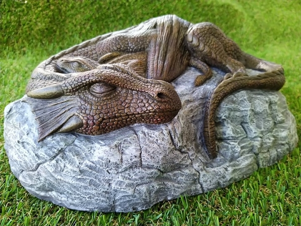 Dragon and her baby sleeping on a rock garden ornament